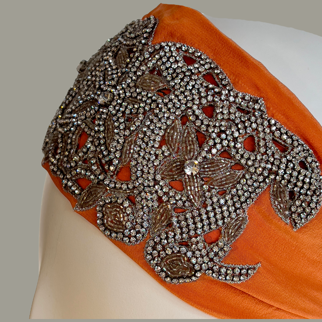 Hand embroidered orange and silver crystal headband with elastic back.