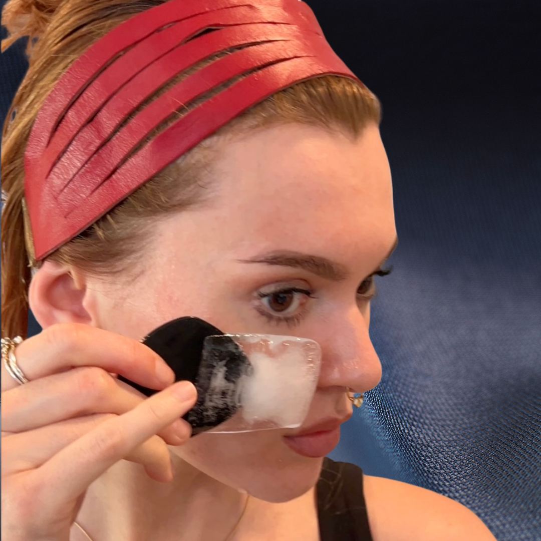 Woman de-puffing face with Glissage ice massage tool