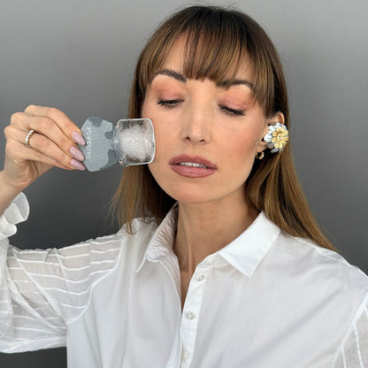 Woman using Glissage, a no oil guasha, to massage her face.