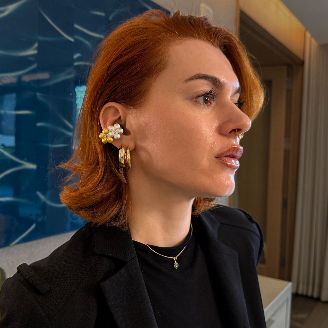 Stylish young woman wearing Priamble Smart earphone Earrings by Peripherii  in gold/silver