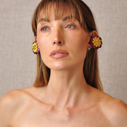 PERIPHERII PRIAMBLE Gita Bluetooth earbuds, close-up of burgundy, yellow and gold petals with a crystal center.