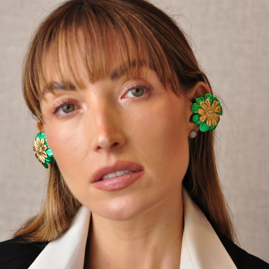 oung woman wearing PERIPHERII PRIAMBLE Gita Bluetooth earbuds with emerald-green and gold floral petals.